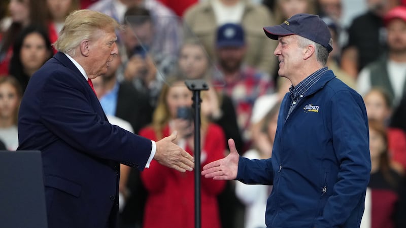 President Donald Trump greets Sen. Dan Sullivan, R-Alaska, at a campaign rally at the Curtis...
